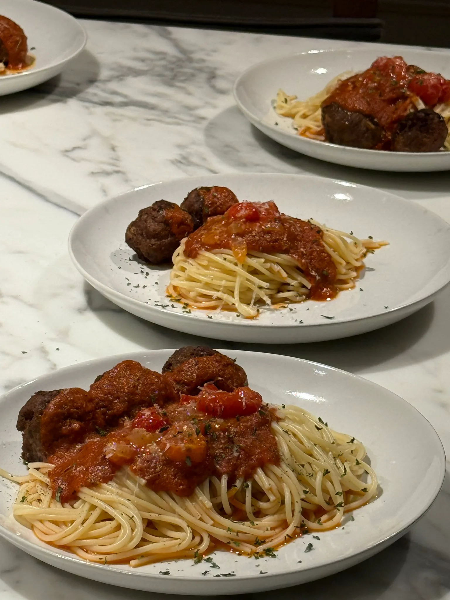 Close-up of spaghetti and meatballs with chunky tomato sauce and herbs