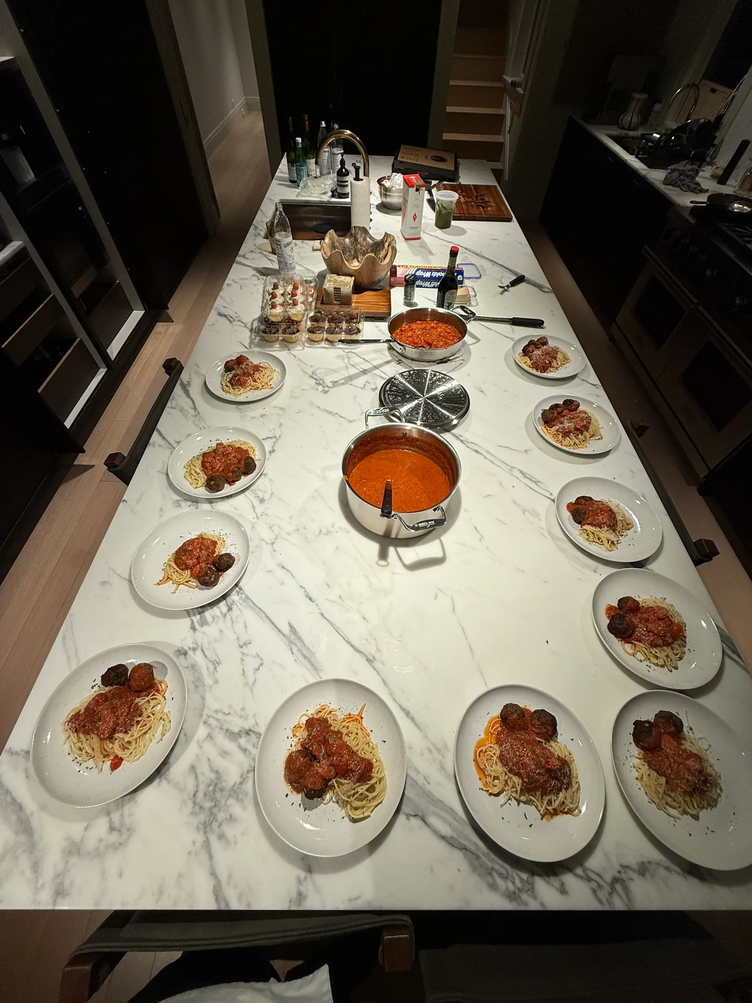 Full kitchen island spread of spaghetti and meatballs dinner party